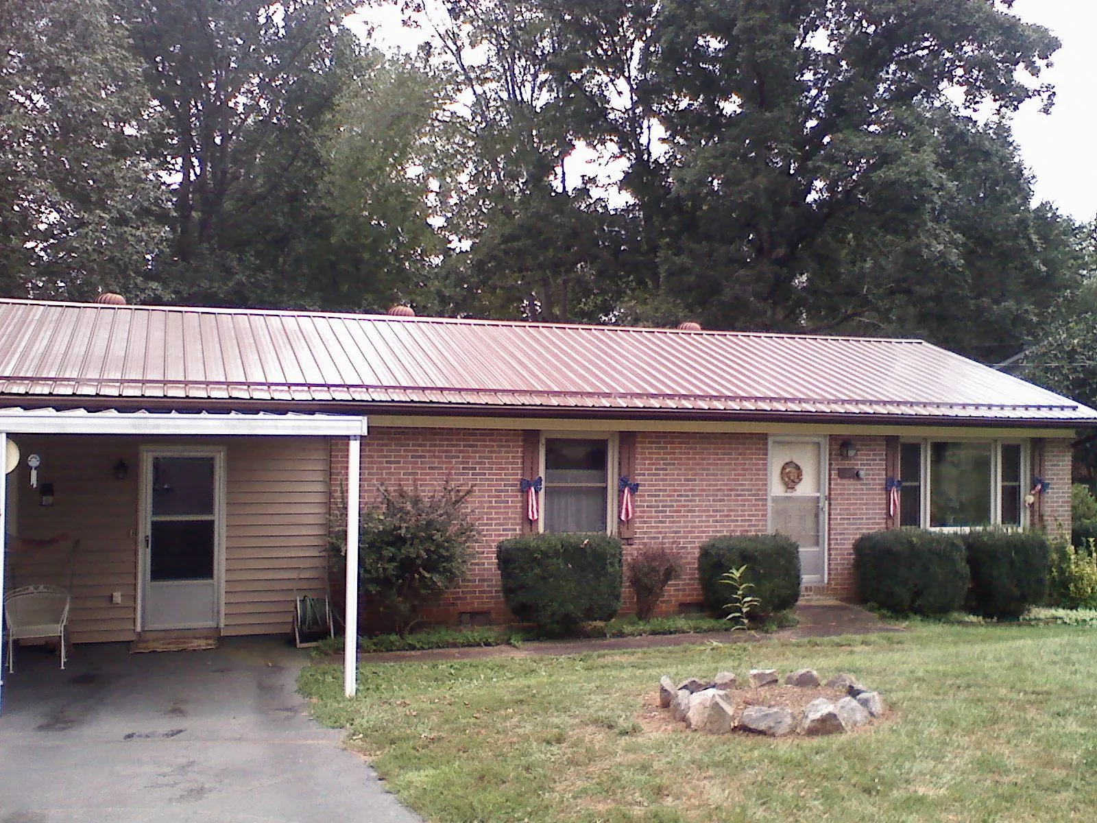 Bronze metal roof and carport on a brick ranch home — Roof Repair work by our crew in Barnardsville