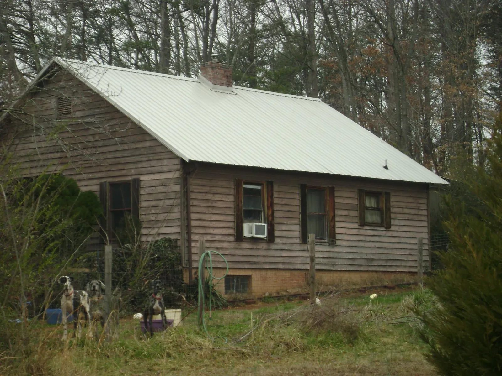White metal roof on an old wood sided farmhouse, from a Metal Roof Installation job in Barnardsville